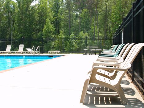 Row of adirondack chairs on a pool deck