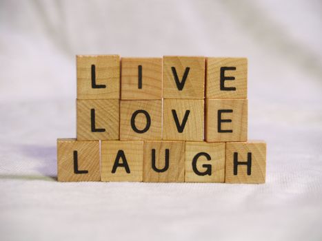 The words LIVE LOVE and LAUGH spelled out with wooden tiles
