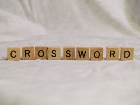 The word CROSSWORD spelled out with wooden tiles