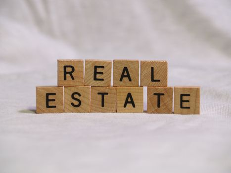 The words REAL ESTATE spelled out with wooden tiles