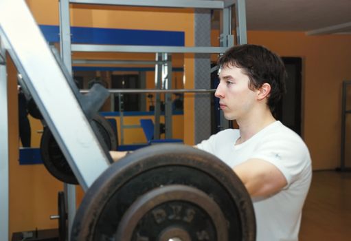 Young bodybuilder in a gym at workout.