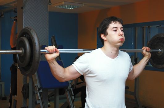 Young bodybuilder in a gym at workout.