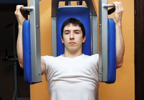 Young bodybuilder in a gym at workout.