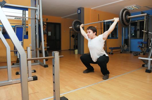 Young bodybuilder in a gym at workout.