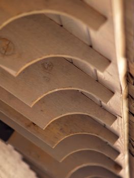 Closeup detail of the wooden beams of a park shelter over a picnic area. A decorative quarter-round has been cut into the end of each board. 