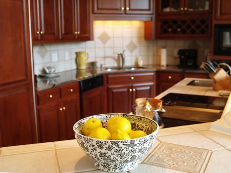 A bowl of lemons on a marble countertop in a luxury kitchen