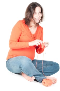 Portrait of pretty pregnant woman knitting, isolated on white