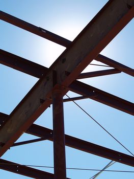 Metal girders and crossbracing in a new commercial construction project silhouetted against the sky.