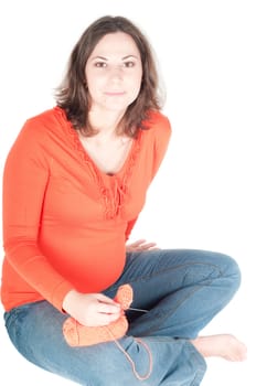 Portrait of pretty pregnant woman knitting, isolated on white