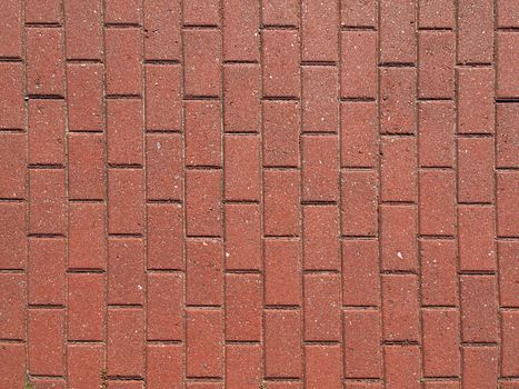 Closeup of the pattern of a red brick paved walkway.