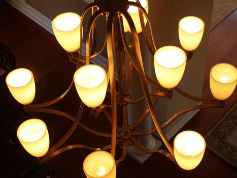 Top view of a hanging brass or copper light fixture with upturned glass shades