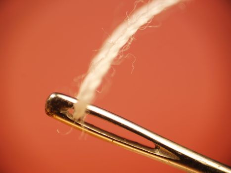 Macro of a sewing needle and white thread