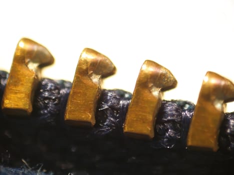 Macro of four teeth from a zipper found on clothing