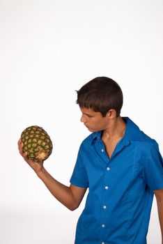 Teen practicing weightlifting with a pineapple, nutrition concept