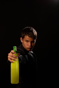 Teenager impersonating James Bond holding a cleaning spray