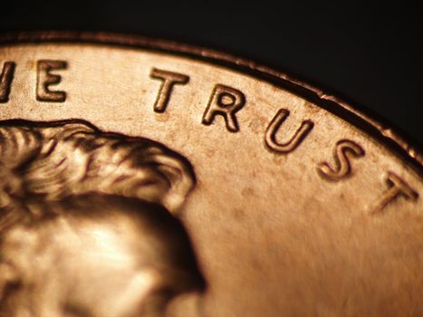 Macro of a penny focusing on the words "WE TRUST"