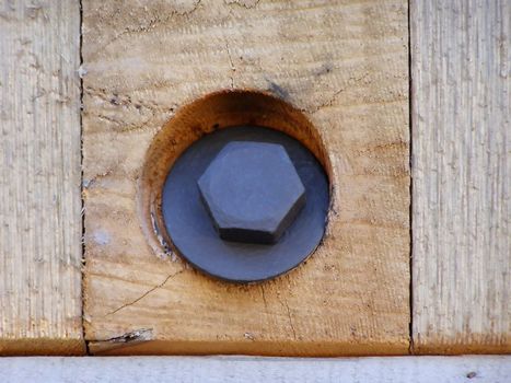 Large bolt and washer recessed in a rough cut beam