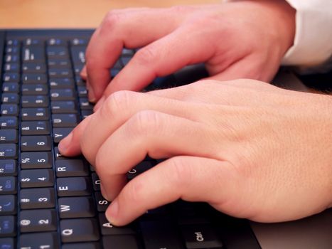 Closeup of a man typing on a laptop computer