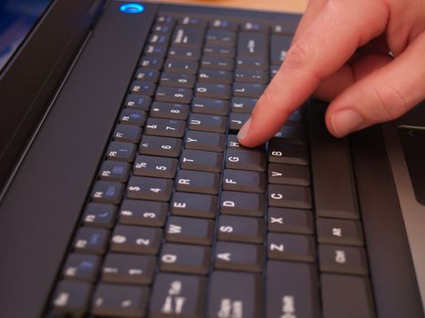 Male finger on laptop keyboard