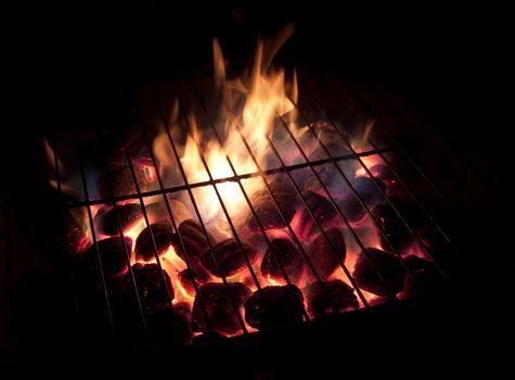 Long exposures of coals buring underneath a grill.