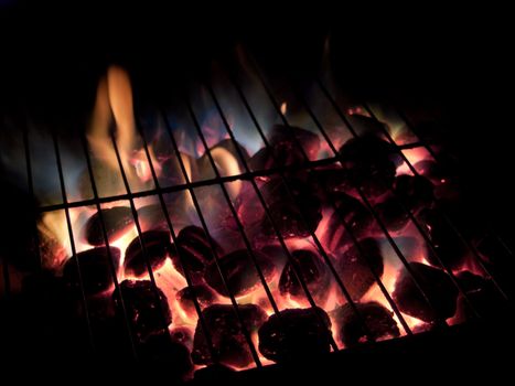 Long exposures of coals buring underneath a grill.