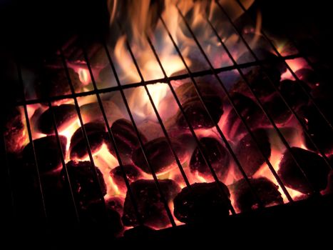 Long exposures of coals buring underneath a grill.