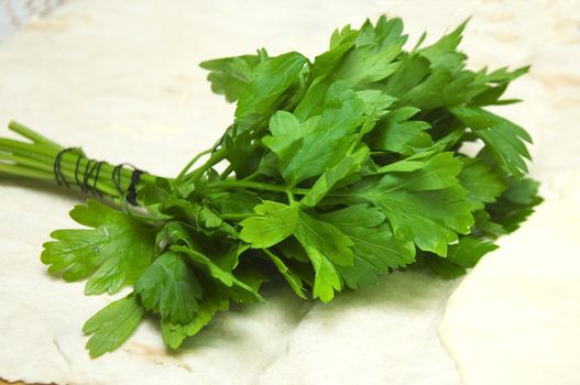 Leaf of parsley on a bread board isolated on the white background