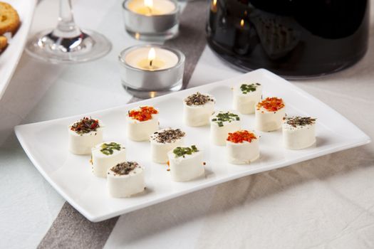 Cheese appetizers on table with wine and candles.