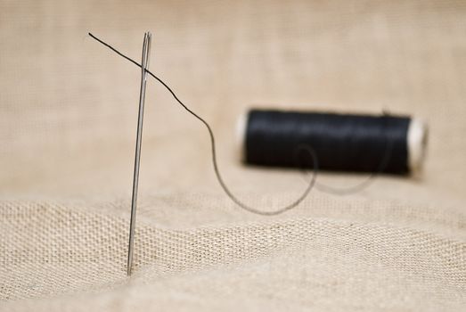 Utensils for sewing on a piece of burlap.