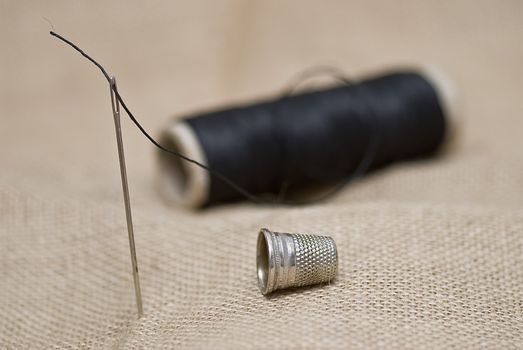 Utensils for sewing on a piece of burlap.