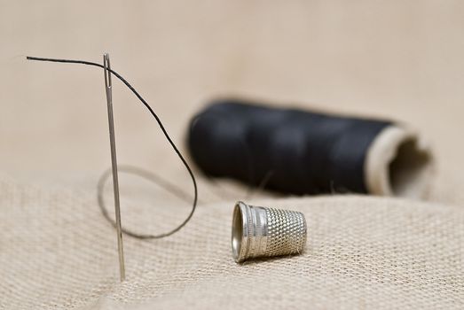 Utensils for sewing on a piece of burlap.