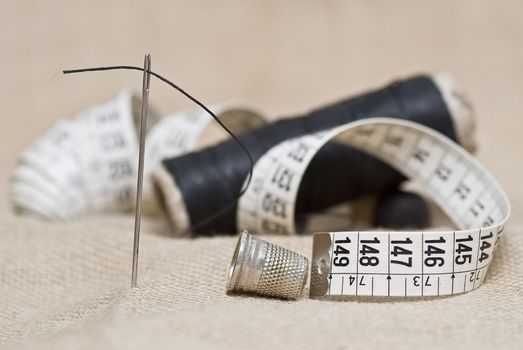 Utensils for sewing on a piece of burlap.