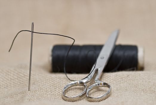 Utensils for sewing on a piece of burlap.