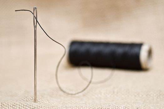 Utensils for sewing on a piece of burlap.