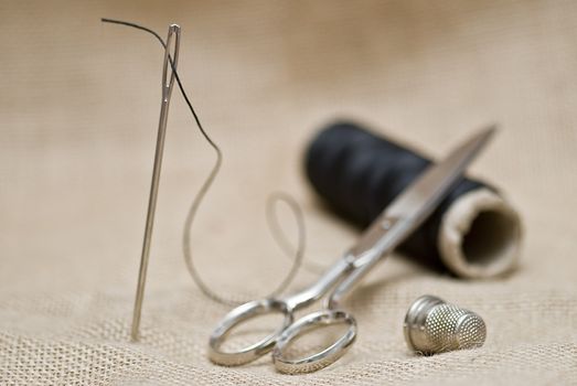 Utensils for sewing on a piece of burlap.