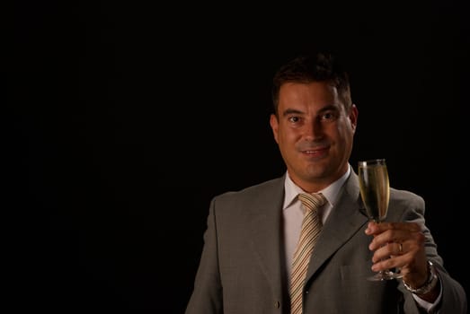 Man dressed in suit toasting with a champagne flute