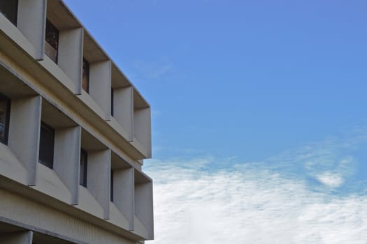 Modern university building against a blue sky and white cloudscape