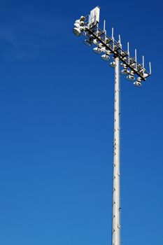 Sporting Field lights on top of tall steel pole with dark blue sky background