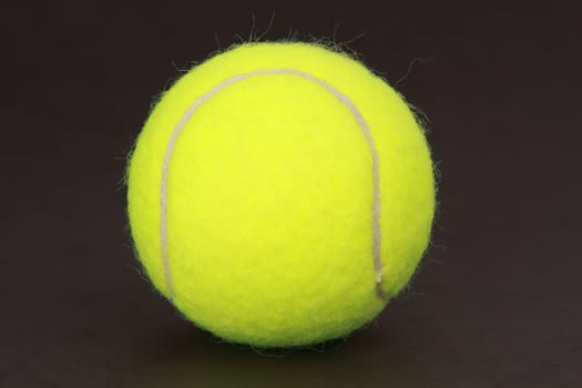 yellow new tennis ball, black background