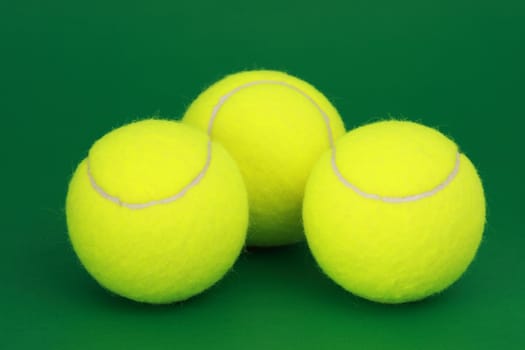 three yellow new tennis ball, green background