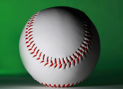 single new baseball ball, green background