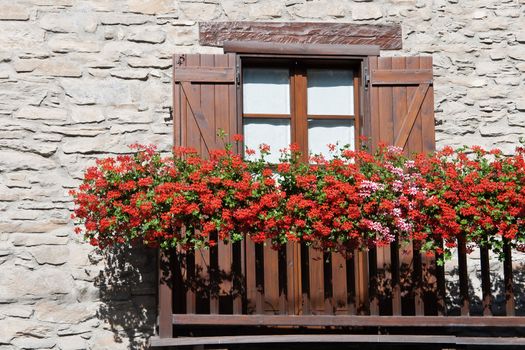 characteristic alpine balcony with red and pink geranium flowers