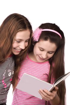 Two girls in the age of ten and eleven reading and smiling isolated on white