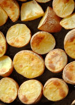 baked brown potato pieces on black background