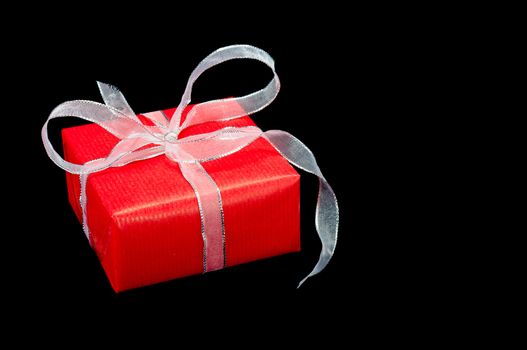 Single red and silver Xmas gift box on a black background