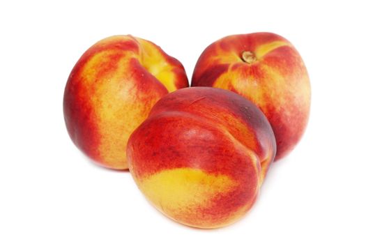 Three tasty juicy peaches on a white background