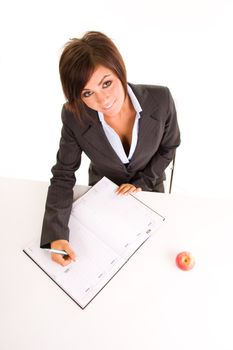 Young business woman writing in a diary