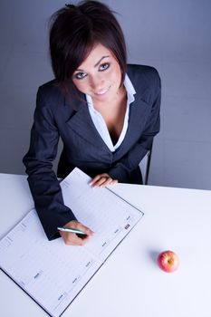 Young business woman writing in a diary