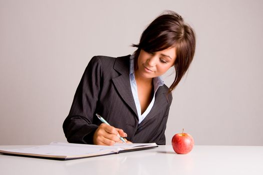 Young business woman writing in a diary