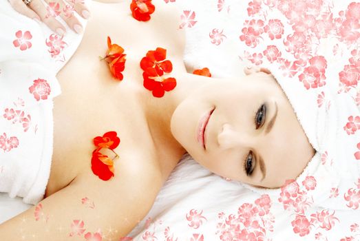 beautiful lady with red flower petals in spa